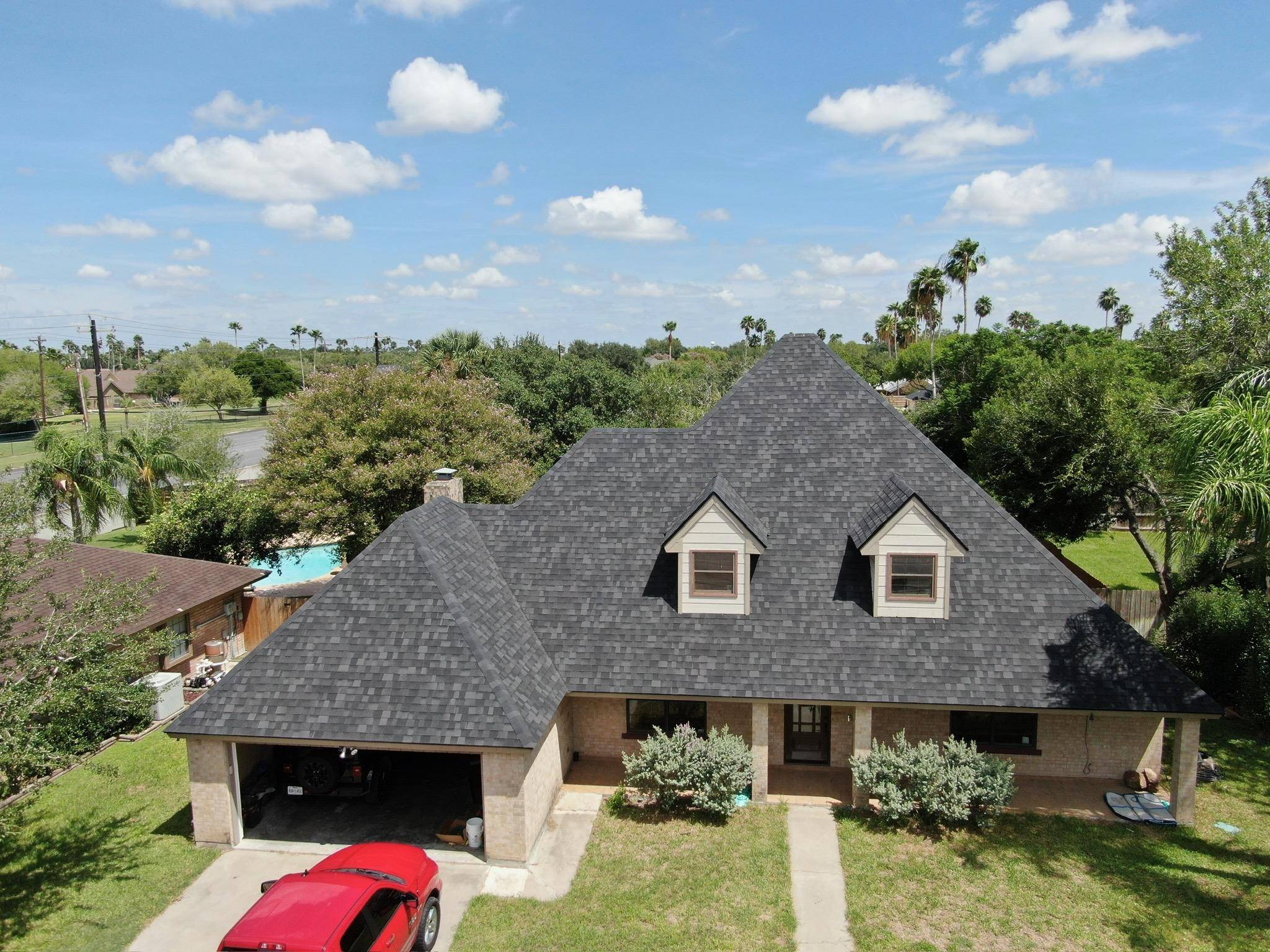 “Close-up of asphalt shingles on a Texas home before the factory sealant has fully activated”